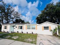Charming home featuring a bright exterior, complemented by neat landscaping and decorative window shutters at 1300 21St S St, St Petersburg, FL 33712