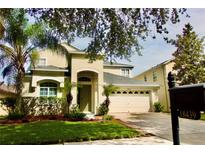 Charming two-story home featuring a well-manicured lawn, a two car garage and lush landscaping at 18439 Red Willow Way, Land O Lakes, FL 34638