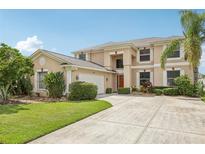 Charming two-story home featuring a well-manicured lawn and a spacious driveway at 25737 Frith St, Land O Lakes, FL 34639