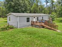 Charming single-story home features a wooden ramp leading to a cozy front deck at 26223 Chianina Dr, Wesley Chapel, FL 33544