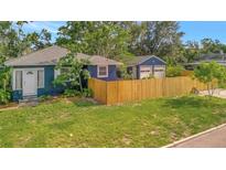 Charming blue home featuring a fenced yard and detached two-car garage at 301 Kingston S St, St Petersburg, FL 33711