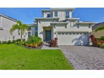 Charming two-story home with manicured lawn, beautiful landscaping, and a paver driveway at 955 Signet Dr, Apollo Beach, FL 33572