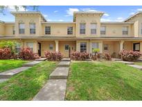 Charming townhome featuring a well-manicured lawn, walkway, and inviting facade under a clear blue sky at 10947 Brickside Ct, Riverview, FL 33579