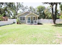 Charming single-story home featuring a well-maintained lawn and inviting front porch at 1103 E Lambright St, Tampa, FL 33604