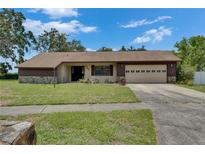 Charming single-story home with a well-maintained lawn and a two-car garage at 1309 Sandalwood Dr, Plant City, FL 33563