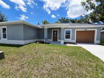 Charming single-story home with a well-maintained lawn, light gray stucco, and a one-car garage at 1557 S Martin Luther King Jr Ave, Clearwater, FL 33756