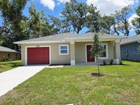 Charming single-story home with a well-manicured lawn and a red garage door at 1561 S Martin Luther King Jr Ave, Clearwater, FL 33756