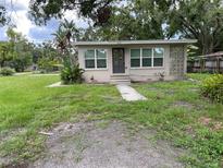 Charming single-story home featuring a landscaped front yard and neutral color palette at 1619 E Nome St, Tampa, FL 33604
