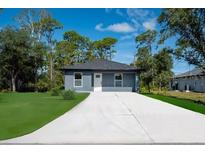 Charming single story home featuring a large driveway and a well manicured lawn at 163 Swift St, Port Charlotte, FL 33954