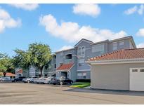 Attractive three-story apartment building with ample parking and tiled roof detail at 18001 Richmond Place Dr # 116, Tampa, FL 33647