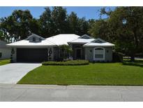 Charming single-story home featuring a metal roof, well-manicured lawn, and two-car garage at 3212 Stevenson St, Plant City, FL 33566