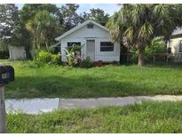 Quaint single-story home featuring a simple front facade and tropical landscaping, offering a cozy and relaxed curb appeal at 518 Woodlawn St, Clearwater, FL 33756
