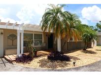 Charming home with a pergola-covered front entrance, palm trees, and well-maintained landscaping at 6045 2Nd N Ave, St Petersburg, FL 33710
