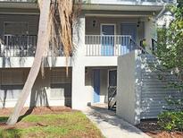Condo with two stories, with a tree and stairs leading to the second floor at 7148 E Bank Dr # 7148, Tampa, FL 33617