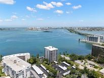 Breathtaking aerial view overlooking waterfront condos with city skyline in the distance under a bright blue, partly cloudy sky at 80 Rogers St # 3A, Clearwater, FL 33756