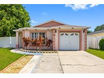 Charming single-story home featuring a one-car garage and lush landscaping at 8502 N Hyaleah Rd, Tampa, FL 33617