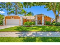 Charming single-Gathering home with a well-manicured lawn, mature trees, and inviting curb appeal at 1111 Chatham Ct, Safety Harbor, FL 34695