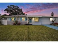 Charming single-story home with a well-manicured lawn, blue shutters, and a freshly painted exterior at 11416 126Th N Ave, Largo, FL 33778