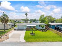 Charming single-story home with lush lawn, pretty landscaping, and a covered front porch at 13316 Carol Dr, Hudson, FL 34667