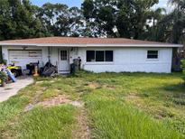 Modest one-story home featuring a simple design and an unkempt front yard with lots of potential at 1580 Tuscola Rd, Clearwater, FL 33756
