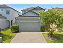 Charming two-story home with a two-car garage, brick driveway, and well-maintained landscaping at 1604 Acadia Harbor Pl, Brandon, FL 33511