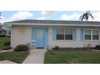 Charming single-story home with a light blue door, shutters, and well-manicured front yard at 402 Dorchester Pl # 44, Sun City Center, FL 33573