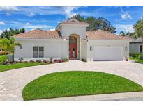Elegant single-story home with a lush lawn, paver driveway and a charming, arched entry at 5217 88Th E St, Bradenton, FL 34211