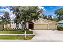 Charming single-Gathering home featuring a well-manicured lawn and a spacious three-car garage at 1216 Fox Chapel Dr, Lutz, FL 33549