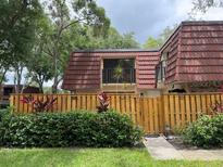Charming townhome with a striking red tile roof and fenced front yard offering curb appeal at 2716 11Th Ct, Palm Harbor, FL 34684