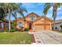 Charming two-story home featuring mature landscaping and a welcoming front entrance at 31241 Kirkshire Ct, Wesley Chapel, FL 33543