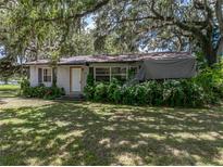 Charming single-story home featuring a cozy front porch and lush, mature landscaping at 4205 Old Mulberry Rd, Plant City, FL 33567