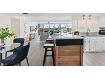 Bright open kitchen with a breakfast bar, stainless steel appliances, and views of the living area and outside at 450 Treasure Isle Causeway # 212, Treasure Island, FL 33706