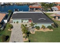 Charming home with a brick driveway, well-manicured lawn, and mature palm trees, creating a welcoming curb appeal at 5133 Glenn Dr, New Port Richey, FL 34652