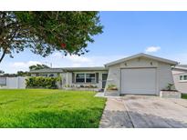 Charming single-story home featuring a well-manicured lawn and attached garage, perfect for comfortable living at 5720 Mockingbird Dr, New Port Richey, FL 34652
