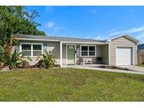 Charming single-story home with a well-maintained lawn, neutral colors, and attached one car garage at 124 E Virginia Ln, Clearwater, FL 33759