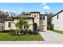 Beautiful two-story home featuring a manicured lawn, mature landscaping, and a neutral color scheme at 14672 Horse Trot Rd, Lithia, FL 33547