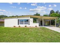 Charming single-story home with a covered carport, neat landscaping, and freshly cut green grass at 2017 Waikiki Way, Tampa, FL 33619