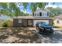 Charming two-story home featuring a stone facade, manicured lawn, and a welcoming front entrance at 208 Se Lincoln N Cir, St Petersburg, FL 33703