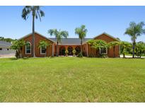 Charming single-story home features a well-manicured lawn and lush tropical landscaping with mature palm trees at 2513 Martucci Rd, Seffner, FL 33584