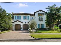 Charming two-story home with a paver driveway, attached two-car garage, and beautifully landscaped yard at 4525 W Swann Ave, Tampa, FL 33609
