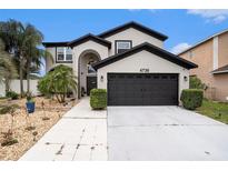 Two-story home with well-manicured lawn, mature landscaping, and a two-car garage at 4738 Bloom Dr, Plant City, FL 33566