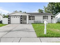 Charming single-story home featuring a manicured lawn and a white picket fence for added curb appeal at 4741 76Th N Ave, Pinellas Park, FL 33781