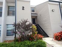 Exterior view of a two-story condo building with black stairs and colorful landscaping at 4811 Puritan Cir # 4811, Tampa, FL 33617