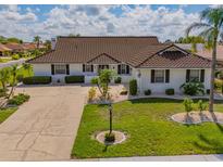 Beautiful single-story home featuring a well-manicured lawn and tile roof at 702 Plumbrook Rd, Sun City Center, FL 33573
