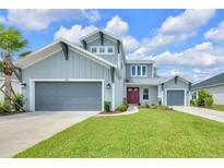 Charming two-story home featuring a well-manicured lawn, two-car garage, and inviting red front door at 7201 Talamore Dr, Wesley Chapel, FL 33545