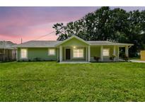 Charming, updated single-story home features a cozy front porch and lush green lawn at 7308 Avonwood St, Tampa, FL 33625