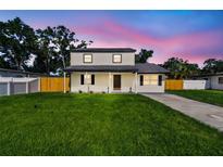 Charming two-story home with a well-maintained lawn and inviting front porch at 7806 N Matanzas Ave, Tampa, FL 33614