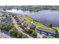 Scenic aerial view of waterfront townhomes, surrounded by lush landscaping and calm lake waters at 8251 118Th Ave # 8251, Largo, FL 33773