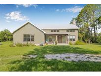 Charming home with a metal roof, covered porch, and a spacious front yard at 8843 Kenton Rd, Wesley Chapel, FL 33545