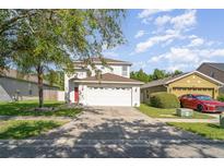 Two-story home boasts a well-manicured lawn and an attached two car garage at 915 Windton Oak Dr, Ruskin, FL 33570